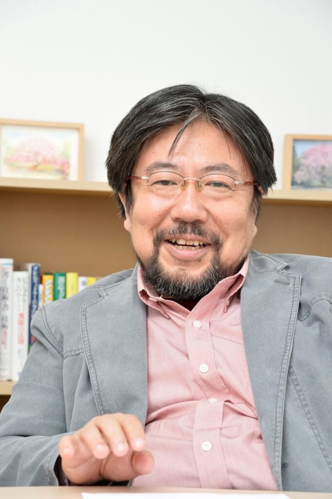 武蔵野大学の鈴木教授が笑顔でこちらを向いています
